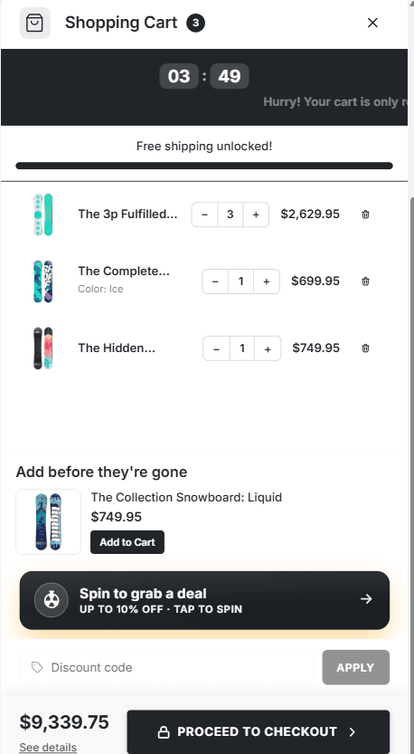 The cart drawer with three snowboards, an upsell row, and a dark Spin to grab a deal button reading Up to 10% off, Tap to spin, above the discount code box